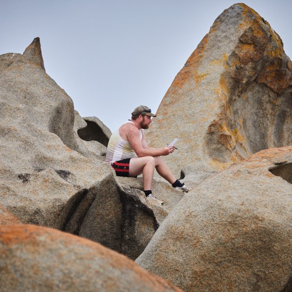 Person sitting on the Remarkable Rocks with a notepad