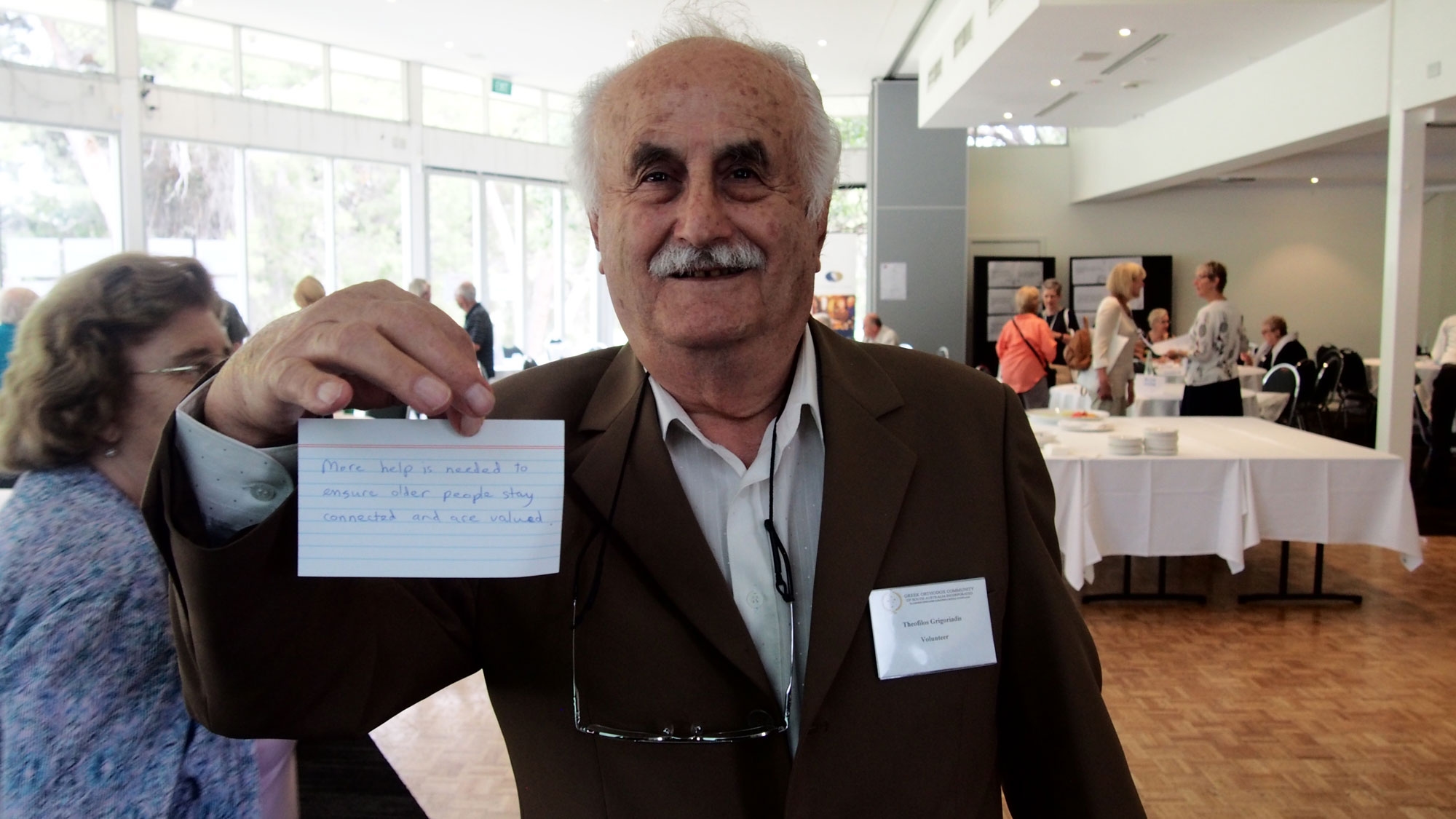 Older man holding up a card with the future of ageing