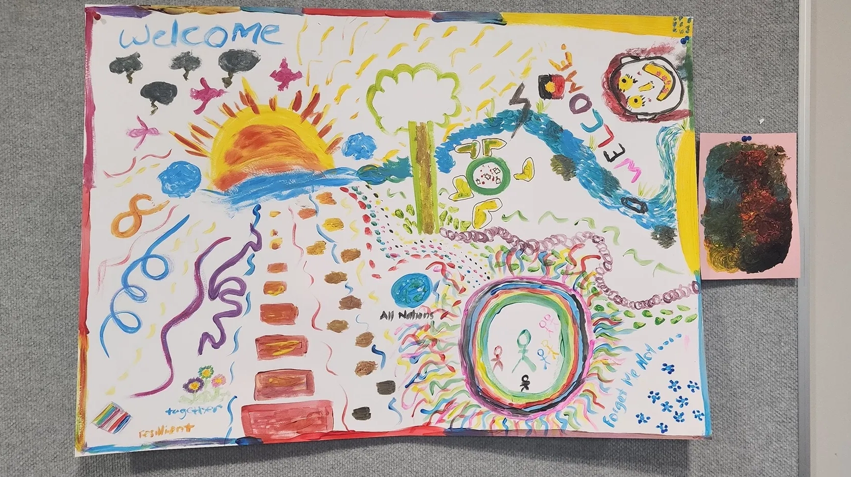 Colourful painting hung on a pin up board with the title 'Welcome'