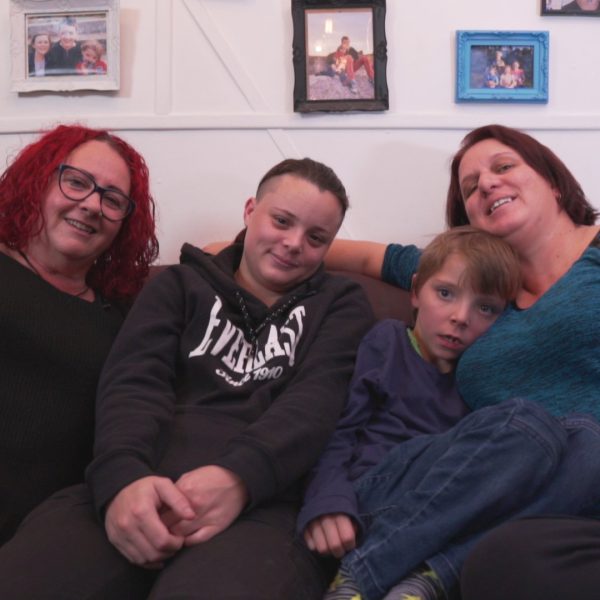 Two women and two kids sitting together on a couch