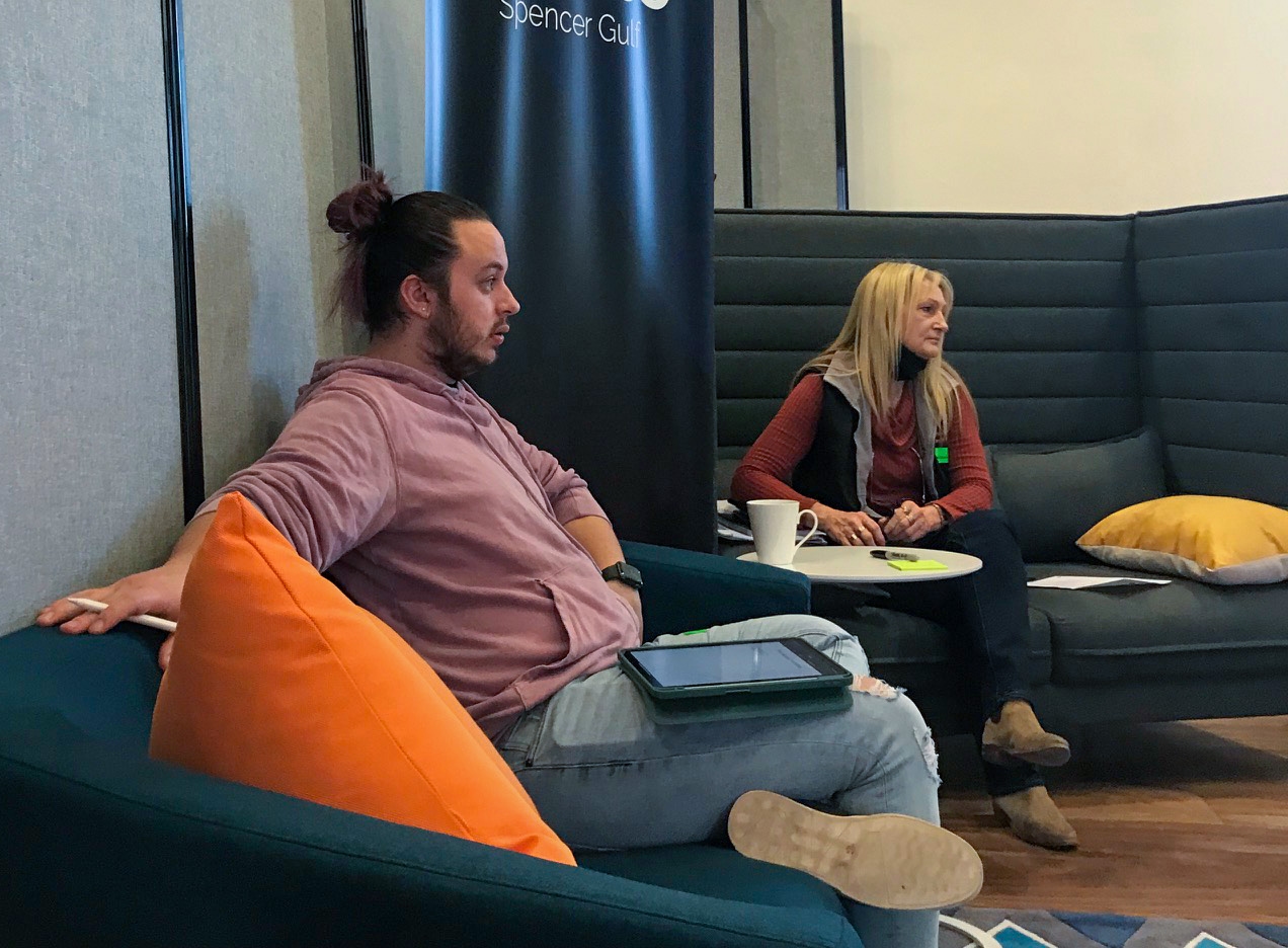 Ashey sitting on a couch in a workshop discussion